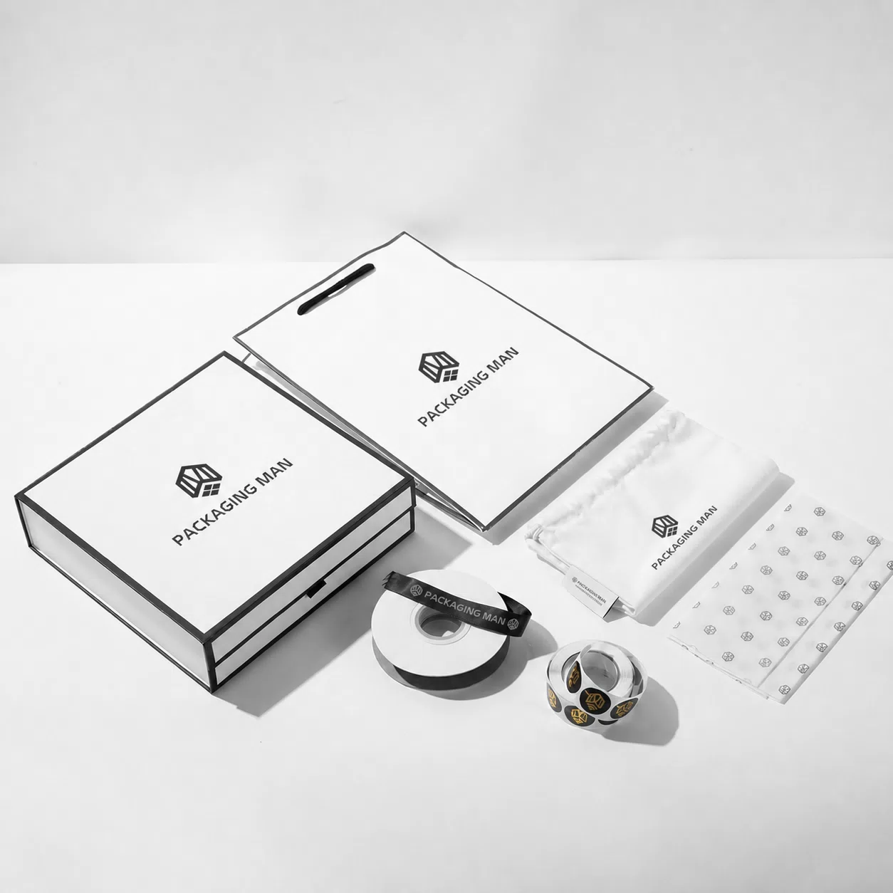 A complete packaging kit layout showing a box, tote bag, ribbon, stickers, a cloth pouch, and patterned tissue paper.